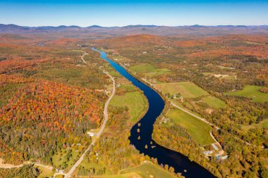 Sonbahar renkli ormanlarda mavi nehir, ufukta dağlar. New Hampshire, ABD. Drone fotoğrafı