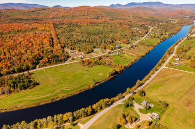 Sonbahar renkli ormanlarda mavi nehir, ufukta dağlar. New Hampshire, ABD. Drone fotoğrafı