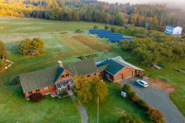 Sonbahar ormanlarında bulutların altında ek binalar olan bir çiftlik. İHA üst görünümü. New Hampshire, ABD