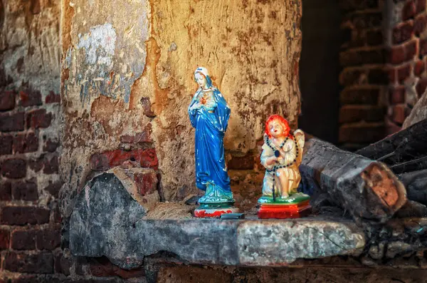 stock image Antique porcelain figurine of Virgin Mary and an angel. Abandoned ruined church, stone stairs