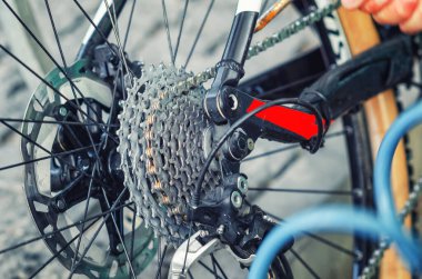 Bicycle chain system. Man's hand tightens the chain on bicycle. Bicycle repair. Maintenance clipart