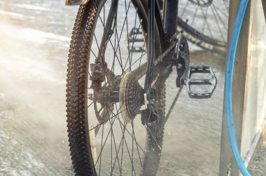 Güçlü su akıntısı bisikleti oto yıkamada yıkar. Yüksek basınçlı pompa. Bakım
