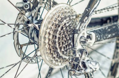 Araba yıkamada büyümüş bisiklet tekerleği, teller, zincir. Köpük jeti ile bisikleti yıkamak. Bakım