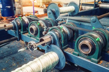 Metal şaftı ve plakası olan büyük bir endüstriyel makine. Kablo sarmak için bobinler. Sanayi tipi