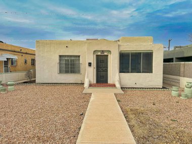 ALBUQUERQUE, New Mexico, ABD - 9 Mart 2023. Ahşap çamur evler. Ahşap pencereler ve kapılar. Evin yanındaki Bush.