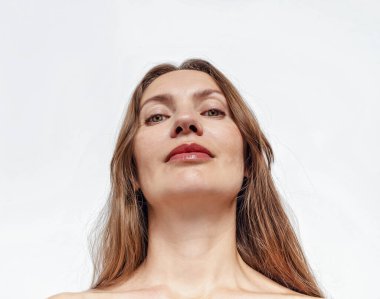 Beyaz arka plana bakan bir kadının portresi.