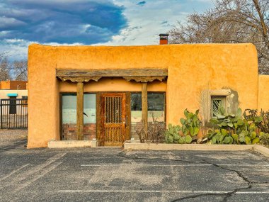 ALBUQUERQUE, New Mexico, ABD - 8 Mart 2023. Terk edilmiş eski ahşap kil ev. Ahşap pencereler ve kapılar. Evin yakınındaki Kaktüs