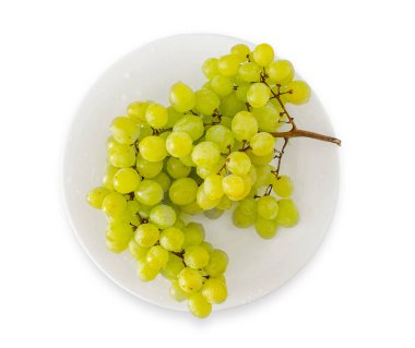 Beyaz tabakta lezzetli taze üzümler. Beyazda izole edilmiş. Vitaminler, meyveler, sağlıklı yiyecekler..
