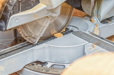 Atölyede küçük bir tahtayı kesen dairesel testere.