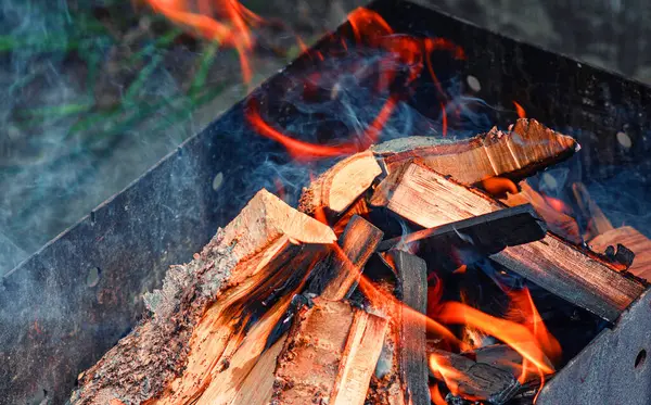 Barbeküde odun yanıyor. Mangal pişirmek için ateş yakıyorum.