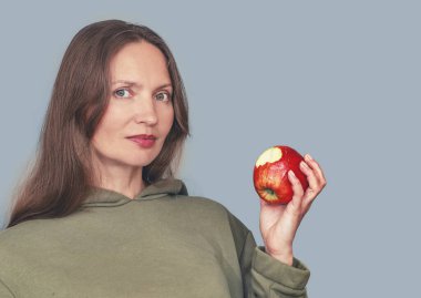 Gülümseyen son sınıf öğrencisi elinde ısırılmış kırmızı bir elma tutuyor. Sağlıklı gıda ve diyet kavramı. Boşluğu kopyala