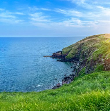 Okyanusun kayalık kıyısı. Ufkun ötesindeki mavi su. İrlanda kıyıları