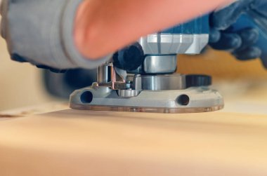 Bir el yönlendiricisinin yakın çekimi ahşap tahta kenarları düzleştiriyor, duyarlı ahşap işçiliği iş başında