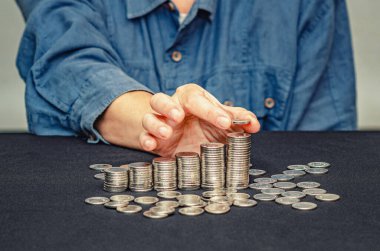 Kadın parmaklarıyla para. Adım büyümesi, para biriktirme, yatırım işi konsepti. Sütunlar halinde sikkeler