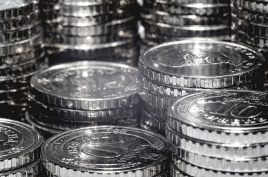 Işık altında gümüş para yığınının makro fotoğrafı. İş ve finans için geçmiş ekonomik eğilimler