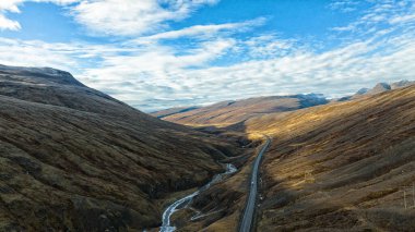 Donmuş nehir ve asfalt yol arasında karlı tepeler arasında mavi gökyüzüne karşı. Havadan manzara manzarası