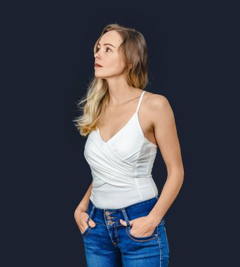 Beyaz tişörtlü ve kot pantolonlu gülümseyen bir kadın siyahın karşısında dikiliyor. Yan görünüm