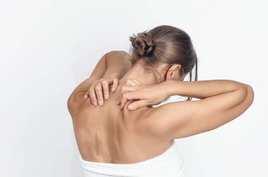 Boyun kaslarına masaj, havlu giymiş bir kadın, beyazlar içinde soyutlanmış. Dikiz aynası. Boyun ağrısının önlenmesi.