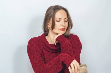 Düşünceli bir kadın hediye paketi yapıp içinde ne olduğunu tahmin ediyor. Hediye kavramı, sürpriz.