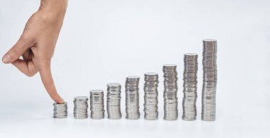Dişi parmak madeni parayı kısa sütuna sıkıştırır. Büyümekte olan gümüş para kolonları. Finansal kazanç, iş açılışı