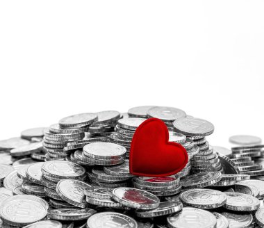 Gümüş para yığınının üzerindeki kırmızı kalp sembolü. Bağış, hayat kurtarma ya da yardım konsepti. Boşluğu kopyala