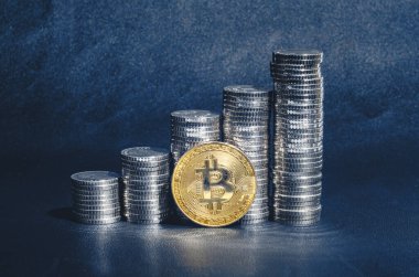 Gümüş para sütunlarının yanındaki altın bitcoin. Kripto para birimi, finans dijitalleştirmesi. Koyu mavi arkaplan