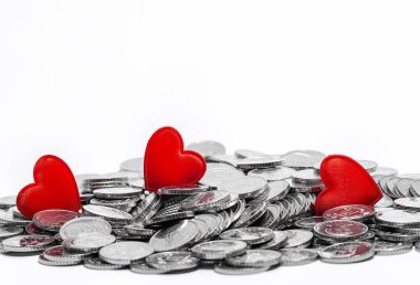 Gümüş para yığını ve beyaz üzerine izole edilmiş üç kırmızı kalp. Tasarım için fikir. Sevgililer Günü kartı.