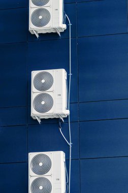 Modern bir binanın duvarında beyaz klima var. Tesislerin havalandırılması
