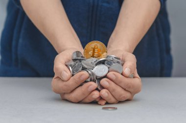 Altın bitcoin 'in ayrıntıları gümüş paralarla dolu kadın avuçlarında. Arka planda bulanık kadın silueti