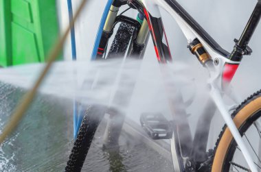 Yeşil zemin üzerinde su jeti olan beyaz çerçeveli bisiklet