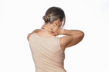 İki eliyle boynunu tutan bir kadın. Bej gömlekli kadın. Boyun ağrısı konsepti. Beyazda izole edilmiş