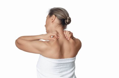 Boyun ağrısı konsepti. Beyaz arka planda boynuna masaj yapan bir kadın. Kemik erimesini önleme, spazmlar. Yan görünüm