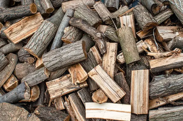 Parçalanmış odun yığını. Yakacak odun yığıyorum. Kış için odun kestim. Doğranmış günlüklerin soyut arkaplanı