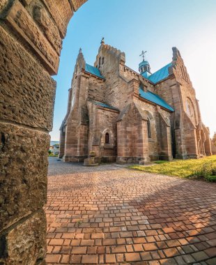 Ukrayna 'nın Butsniv kasabasındaki avluda kaldırım taşlarıyla restore edilmiş eski taş kilise. Aşağıdan kemerli kapıdan görüntüle