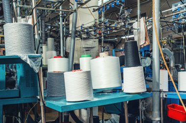 Makinelerdeki beyaz gri ve siyah iplikler. Çorap üretimi için endüstriyel girişim. Modern teknolojiler