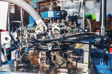 Bulanık arka planda dairesel örgü makinesi. Tekstil endüstrisi, otomatik çorap örgü.