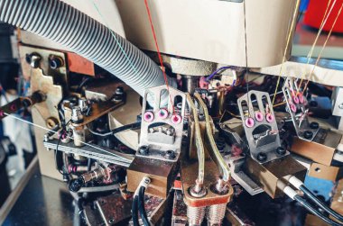 Endüstriyel örgü makinesinin egzoz borusu. Yakın plan. Örgü fabrikasının mekanizmaları. Çorap üretimi