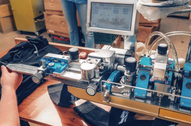 Bir işçinin elleri. Tekstil endüstrisi, otomatik çorap örme. Çorap dikmek için makine