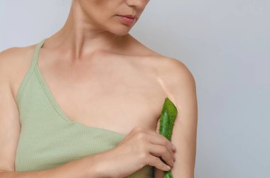 Kadında yara izi, kırık kol. Aloe vera yaprağı, çıplak omuzları ve temiz cildi olan seksi bir kadın portresi..