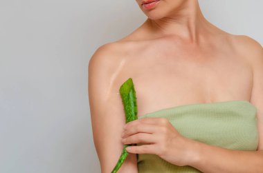 Omzunda yara izi. Aloe yaprağı, kadının omzunda ameliyat sonrası yara izi olduğunu gösteriyor. Yara iyileşme, ciltteki yaraların tedavisi..