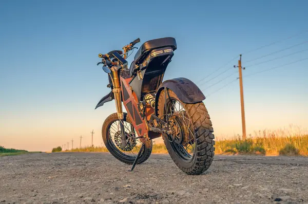 Elektrikli motosiklet, scooter, elektrikli bisiklet. Modern çevre dostu ulaşım. Dikiz aynası. Kırsal yol arkaplanı.