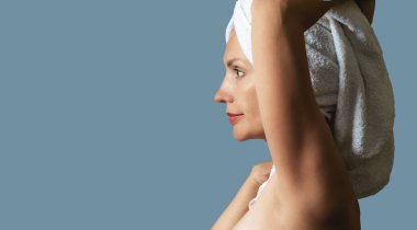 Spa havlusuyla rahatlayan, el ele tutuşan rüya gibi sakin bir kadın. Yan görüş. Güzellik tedavileri, dinlenme ve vücut bakımı prosedürleri. Boşluğu kopyala.