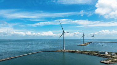 Okyanustaki rüzgâr çiftliği, Hollanda. Bulutlu gökyüzünün altındaki su üzerindeki yel değirmenlerinin havadan görünüşü. Sürdürülebilir kalkınma, yenilenebilir enerji, elektrik üretimindeki yeni teknolojiler.