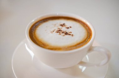 Cappuccino kahveli ve köpüklü beyaz masa.