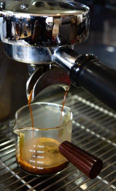 Espresso makinesi kahve demliyor. Kahve dükkanında bardaklara dökülen kahve, kahve makinesinden espresso döküldü