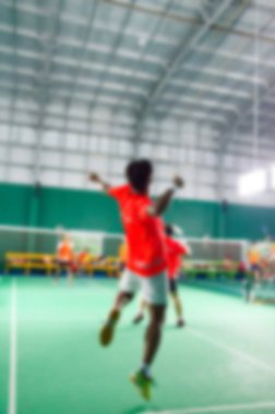 Badminton yeşil mahkemede bulanık oynayanlar.