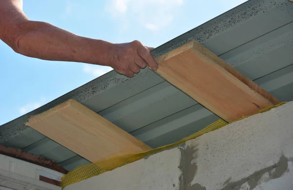 Roofer installing lightweight metal roofing sheets on new house rooftop. Lightweight metal roofing construction.
