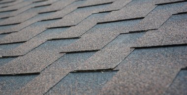 Evin çatısındaki asfalt kiremit dokusunu kapatın. Çatı asfaltının kiremitleri kopyalama alanı ile kutsaldır.