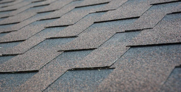 Close up on house roof asphalt shingles texture. Roof asphalt shingles installation consept with copy space.