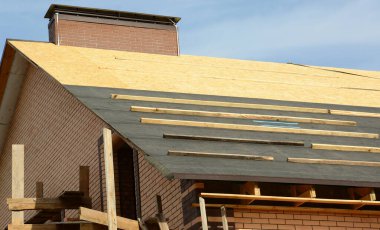 Asfalt kiremitleri döşenmeden önce tuğladan çatı inşaatında buhar bariyeri var. Çatı İnşaatı Harici.